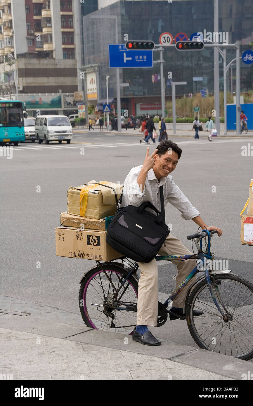 Shenzhen in Cina grattacieli ciclista corriere consegna con HP Hewlett Packard PC scatola di cartone hi-tech low-tech Pearl mistak Delta Foto Stock