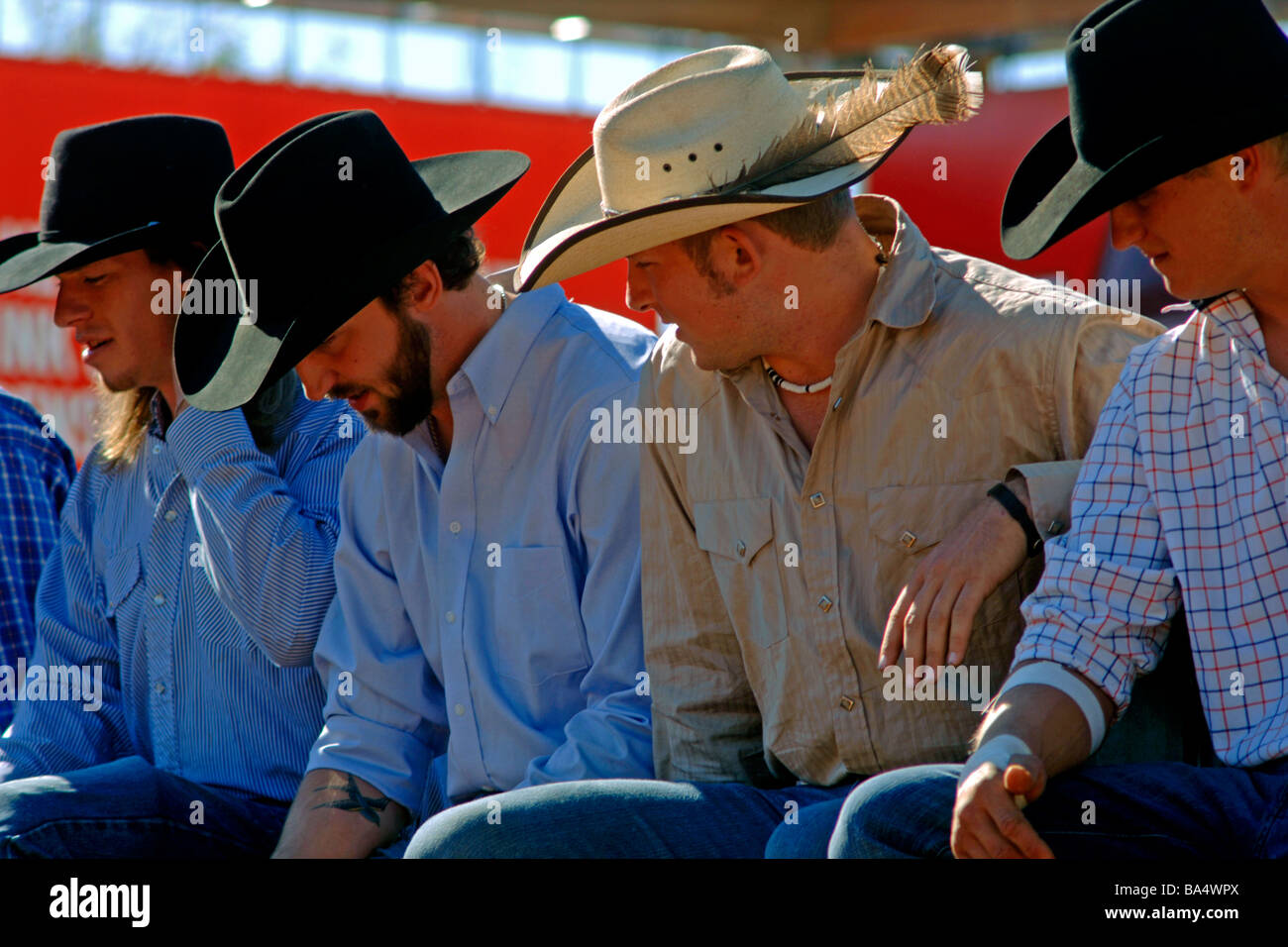 Cowboy in appoggio su una rotaia di recinzione tra tra bull rider eventi al Texas State Fair rodeo Foto Stock