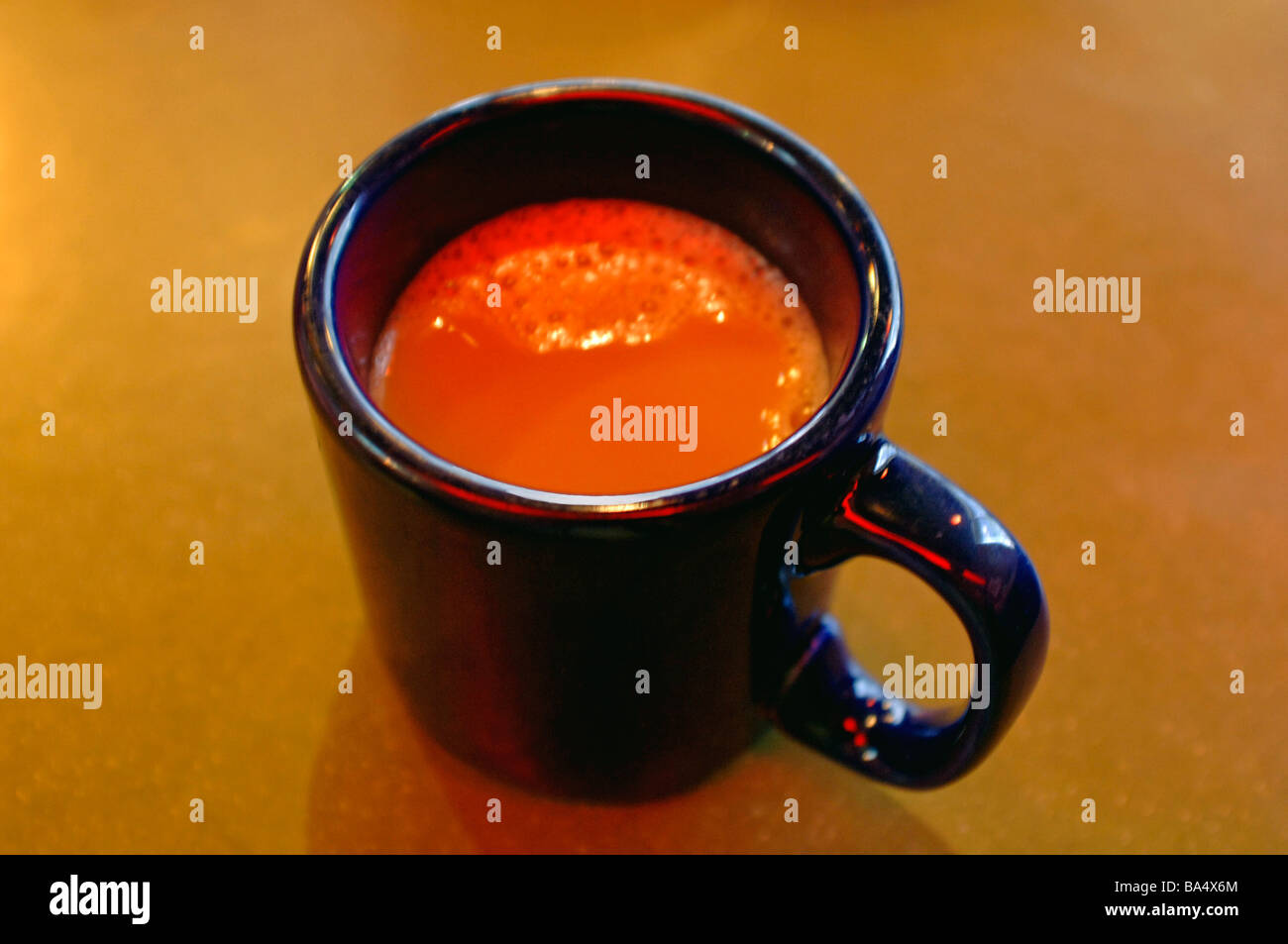 La cottura a vapore caldo cremoso schiumoso, coppa di schiumatura di java, joe, caffè in un colore blu royal cup con panna e zucchero Foto Stock