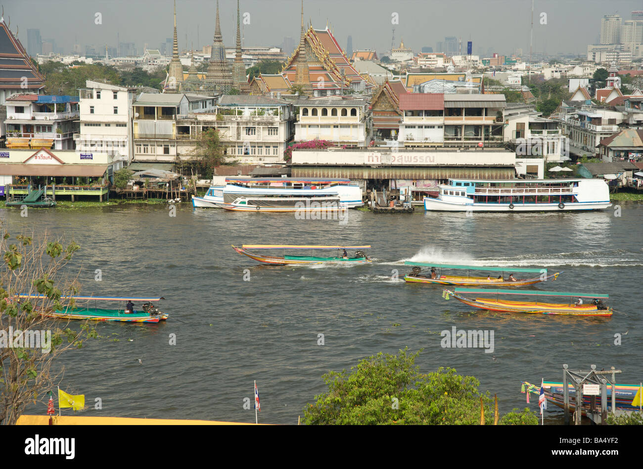 Le barche di taxi a coda lunga passano davanti al tempio di Wat Pho sul fiume Chao Phraya Bangkok Thailandia Foto Stock