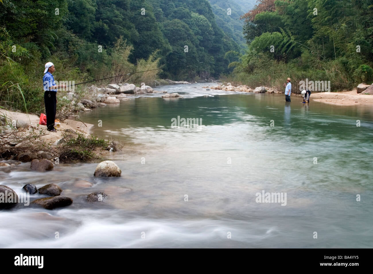 I turisti per la pesca del pesce in un fiume a Nankun nella Riserva Naturale del Guangdong in Cina. Foto Stock
