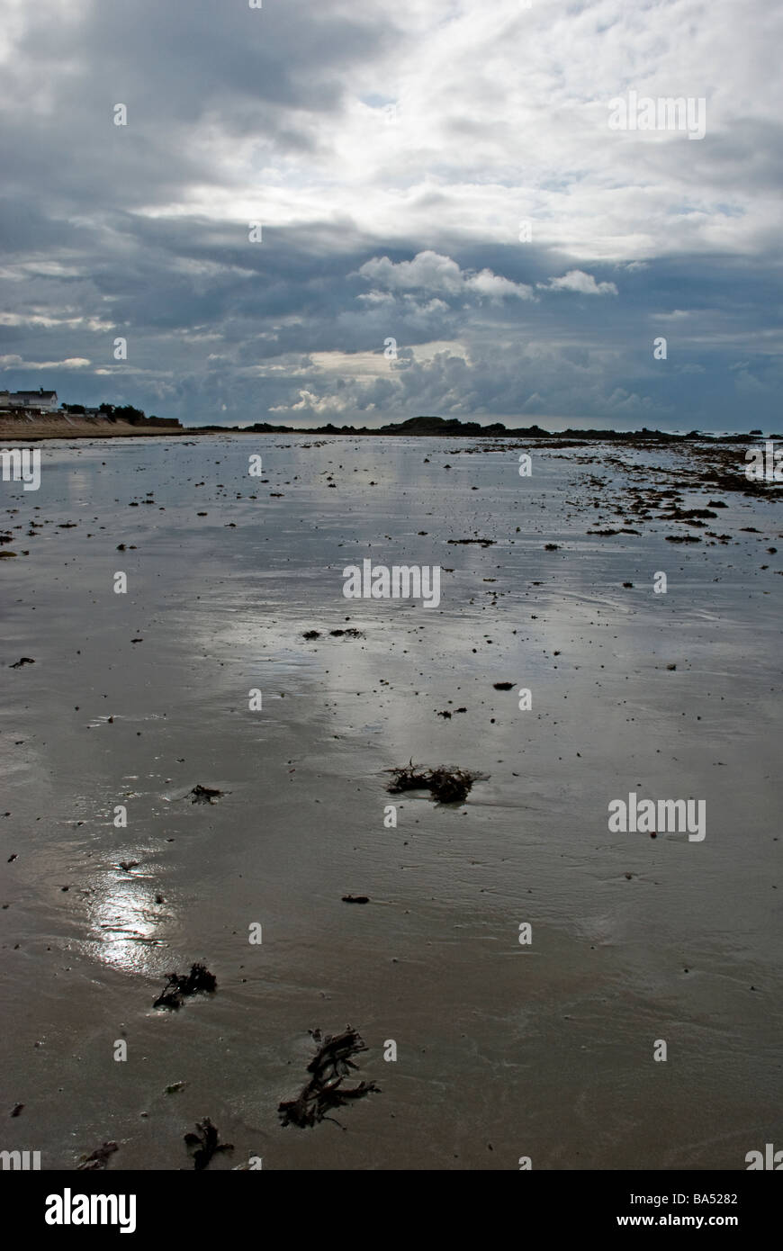 Scena di spiaggia con pioggia nuvole riflettono nella sabbia bagnata jersey Foto Stock