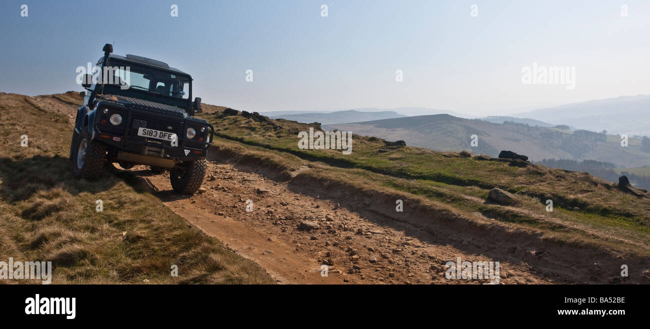 Land Rover Defender scende la via verso il basso il bordo stanage nel Derbyshire Peak District Foto Stock