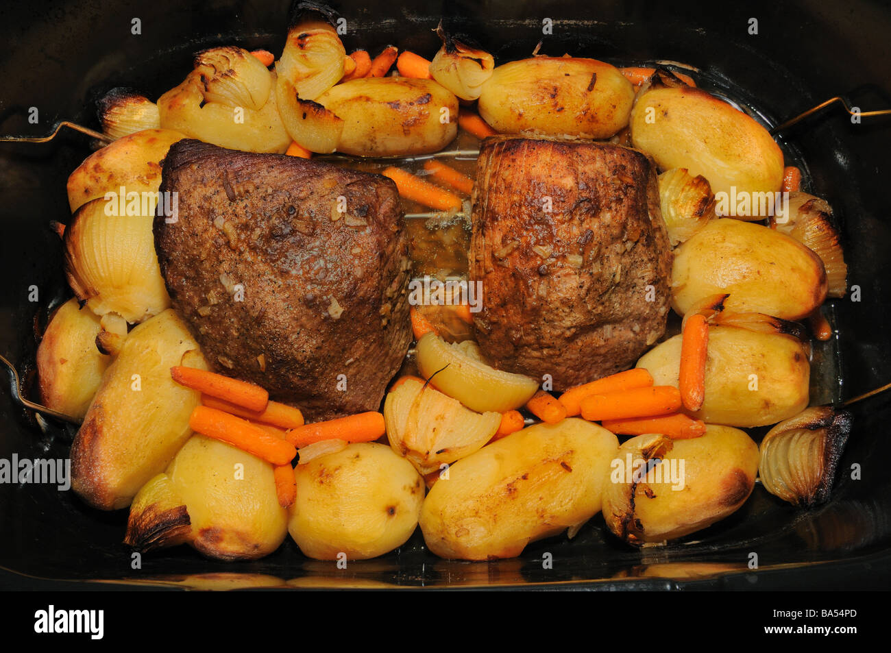 Una deliziosa carne bovina e mandrino round arrosto con patate carote e cipolle saltate con un marrone al sugo di carne. Foto di Darrell Giovani Foto Stock