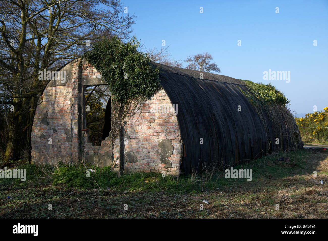 Vecchio abbandonati stagno e mattone guerra mondiale due nissen quonset hut sulla terra di rifiuti ormai abbandonato dalla ex seconda guerra mondiale airbase nella contea di Antrim Foto Stock