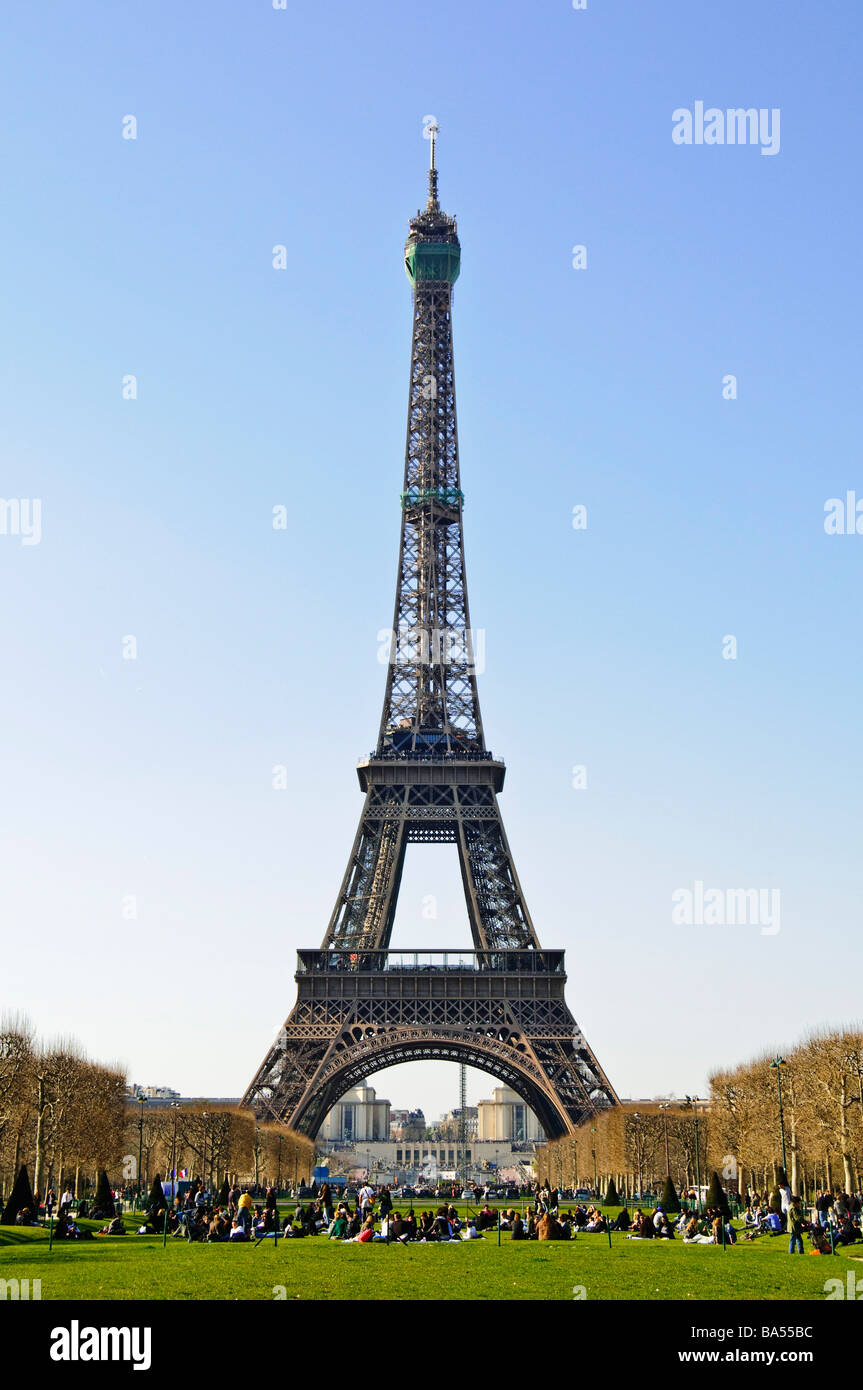 Struttura in ferro battuto della Torre Eiffel dal Parco Champ De Mars Primavera di Parigi Francia // PARIGI, Francia - la Torre Eiffel, un'iconica struttura a reticolo in ferro battuto, si innalza contro un cielo azzurro limpido dal campo di Marte in un giorno di primavera. Progettato da Gustave Eiffel e completato nel 1889 per la Fiera Mondiale, è alto 330 metri (1.083 piedi). La silhouette distintiva della torre è una caratteristica distintiva dello skyline parigino nella capitale francese. La sezione più in alto mostra una rete verde visibile, che indica gli interventi di manutenzione in corso. Questa icona culturale globale è una delle più importanti al mondo Foto Stock