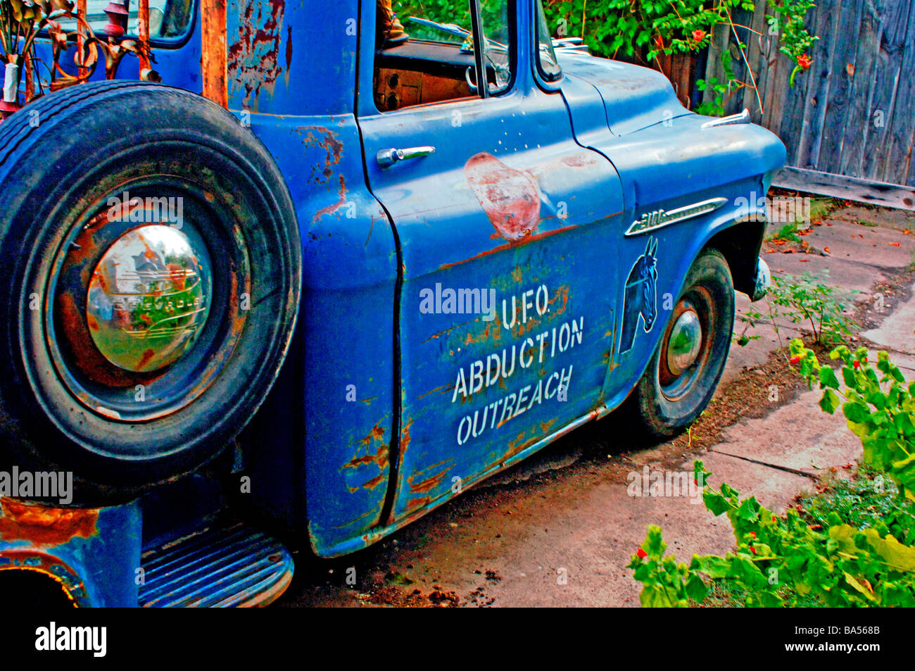 Usurati, weathered, antichi Chevy pick up truck parcheggiato in un viale di accesso con le parole "Rapimento UFO Outreach' dipinta della porta Foto Stock