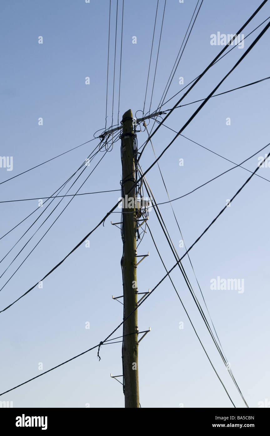Palo di legno con telefono e linee elettriche Foto Stock