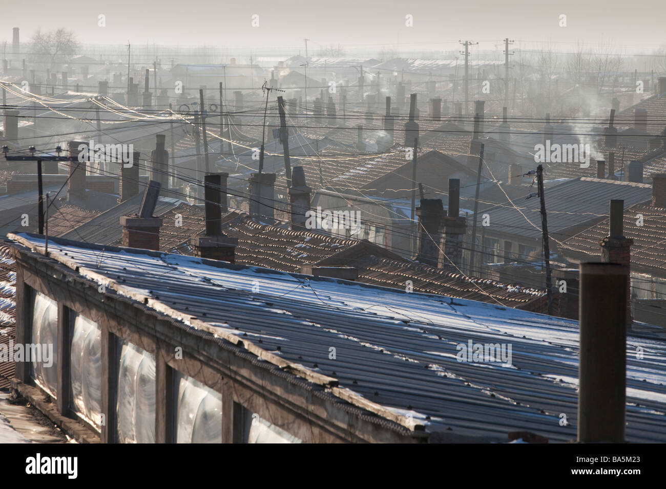 Terribile inquinamento atmosferico da carbone incendi e veicoli pende sopra baraccopoli nella città di Suihua Cina settentrionale Foto Stock