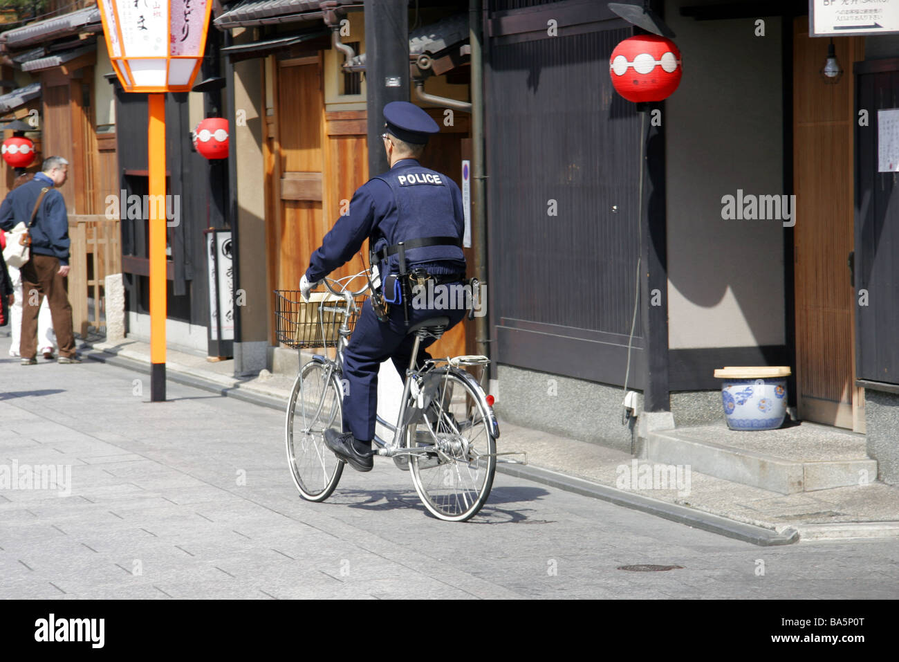 Polizia giapponese officer in sella ad una bicicletta nel quartiere di Gion a Kyoto in Giappone Foto Stock