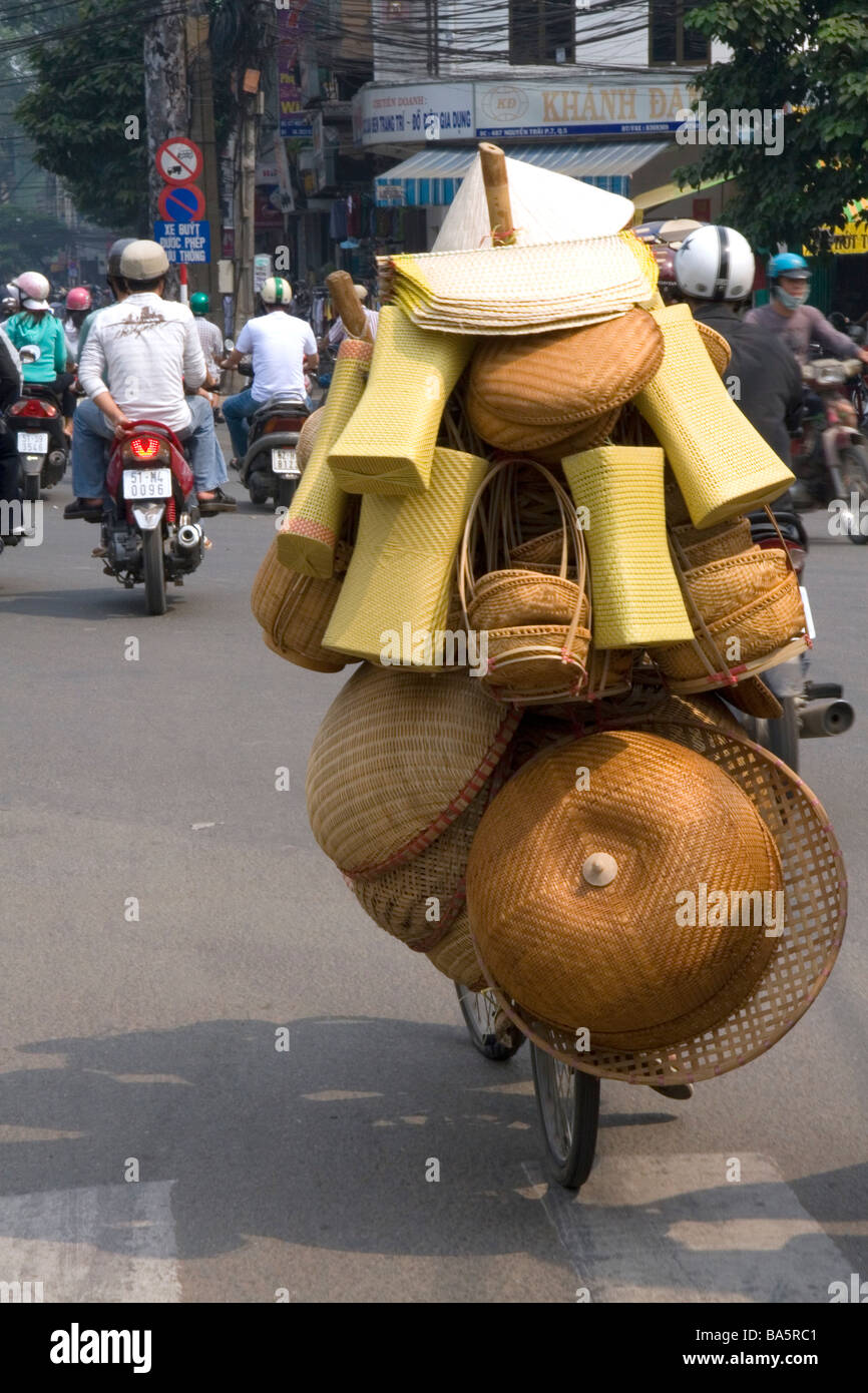 Uomo vietnamita in sella ad una bicicletta con tanti cesti in Ho Chi Minh City Vietnam Foto Stock