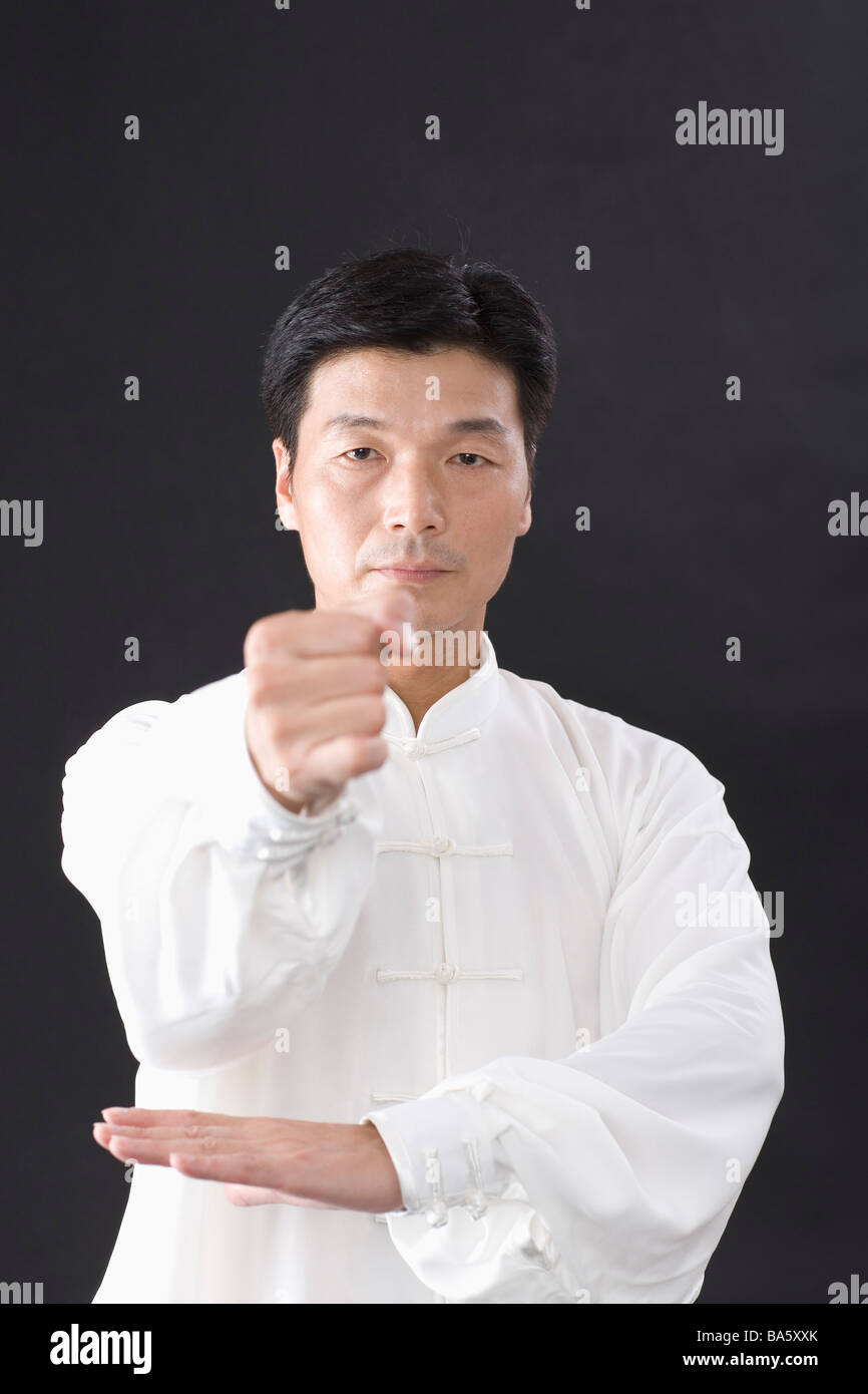L'uomo praticare il Tai Chi su sfondo nero Foto Stock