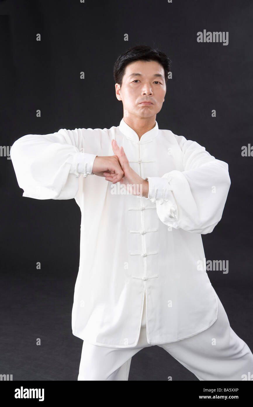 L'uomo praticare il Tai Chi su sfondo nero Foto Stock