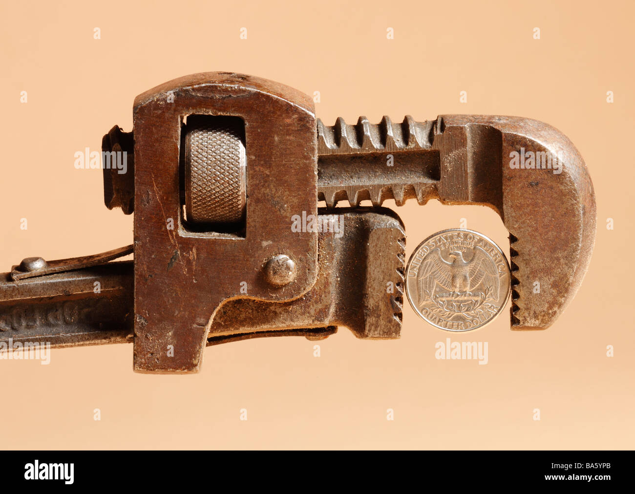 Una chiave regolabile tenendo un quarto di dollaro moneta Foto Stock