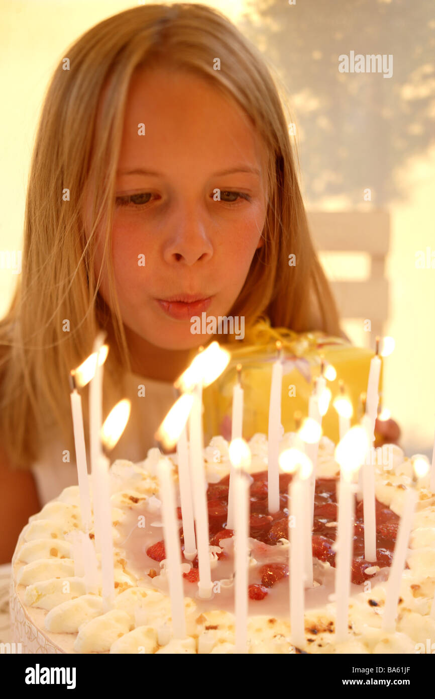 Ragazze compleanno torta di candele si brucia ritratto persone bambino 11 anni bionda con i capelli lunghi a torta di compleanno candele burns si brucia Foto Stock