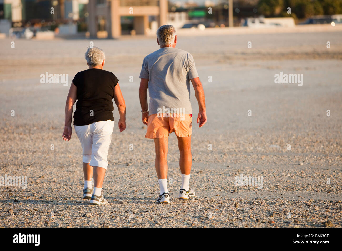 Un sovrappeso coppia di anziani assunzione di esercitare su di una spiaggia pubblica in Dubai UEA Foto Stock