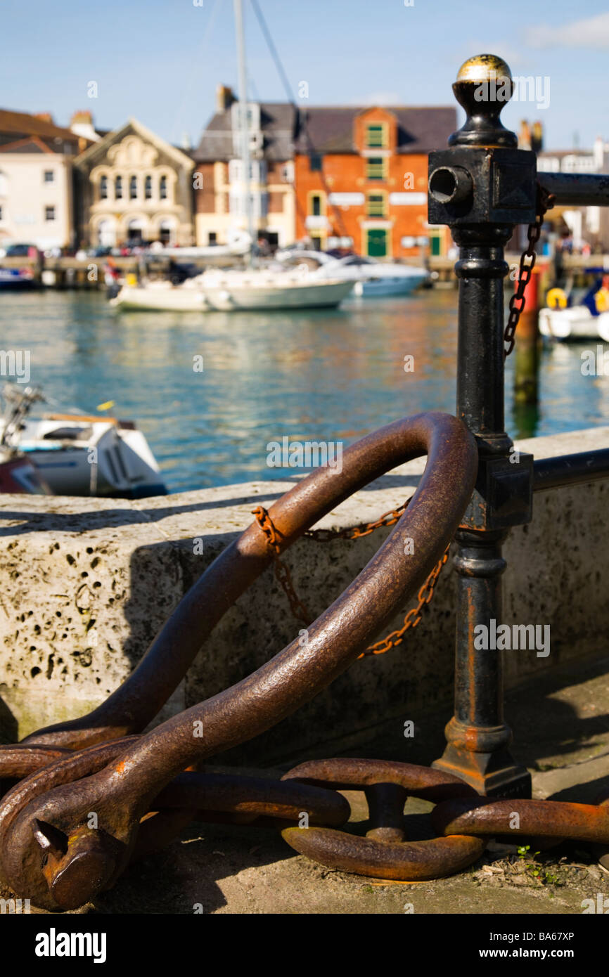 Vecchio arrugginito anello di ormeggio e di catena per la spedizione. Weymouth città porto vecchio. Il Dorset. Regno Unito. Foto Stock