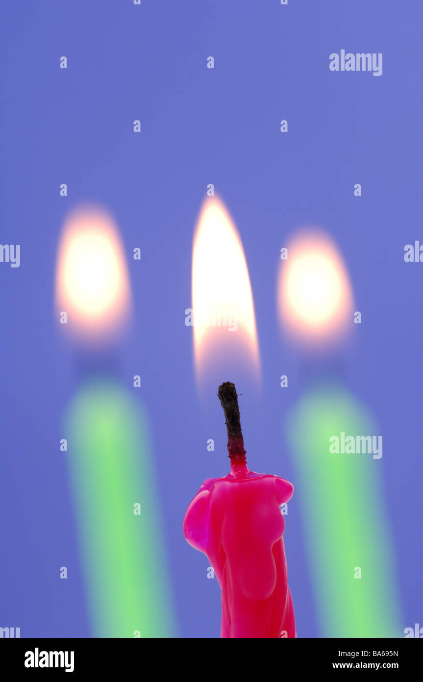 Tre candele differentemente colorato serie ustioni candele di cera compleanno-candele colorate in maniera colorata rosso verde fiamme lume di candela Foto Stock