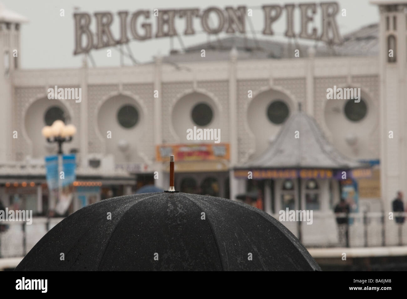 Ombrello nero in pioggia nella parte anteriore del Palace Pier, Brighton Foto Stock