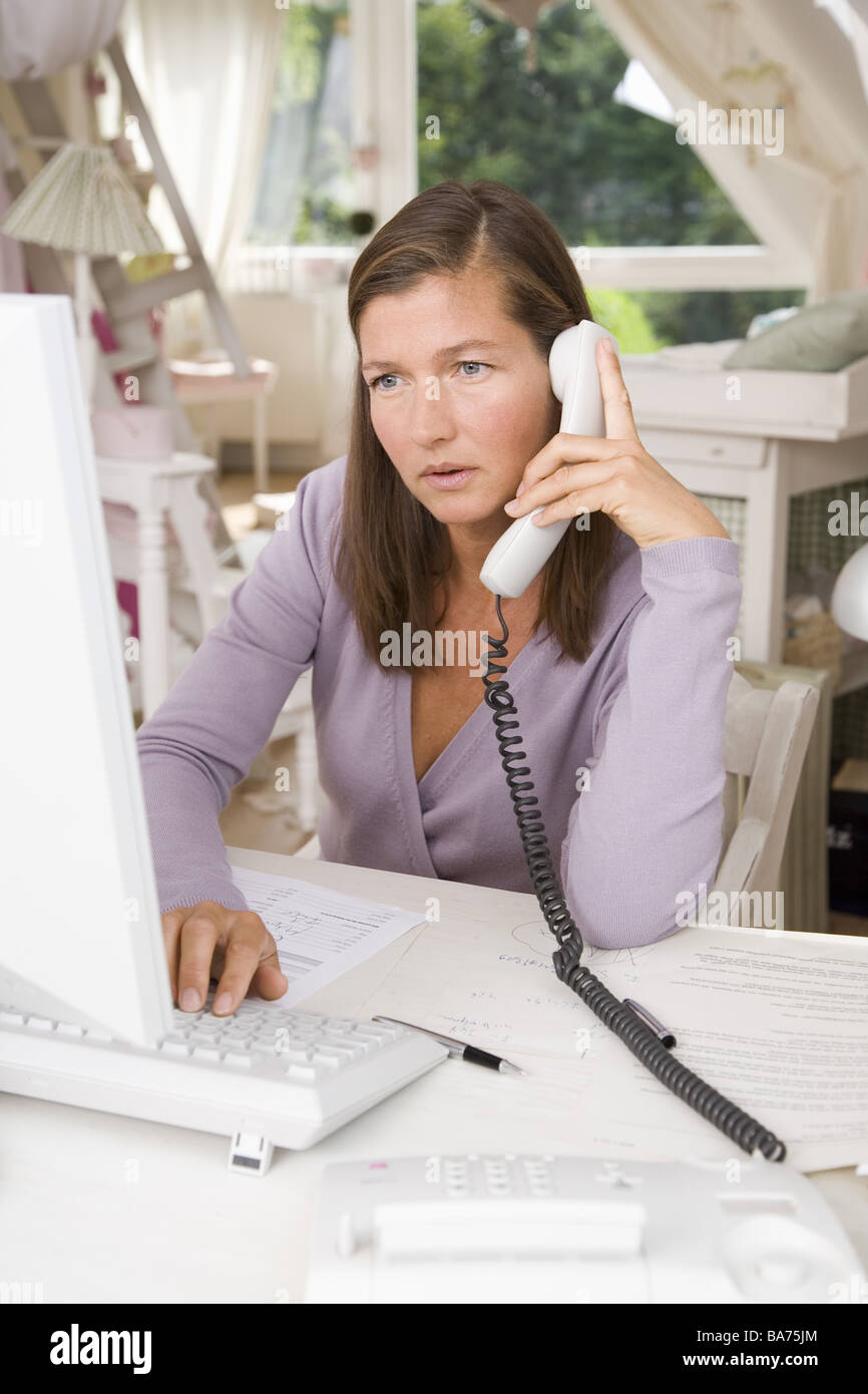 Studi donna desk computer lavora seriamente telefoni semi-portrait appartamento uso ufficio persone 40-50 anni freelance indipendente Foto Stock