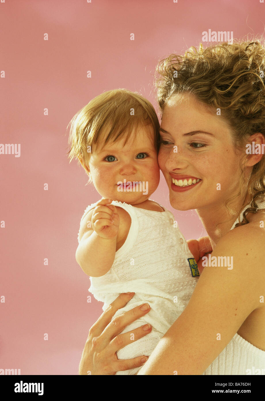 Madre bambino felicemente ride ritratto in studio donna genitore bambino 1 anni baby toddler ragazze lo sguardo amoroso della fotocamera contiene porta Foto Stock