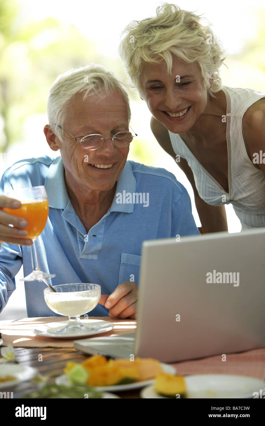 La prima colazione ha spiaggia senior-coppia sguardo allegramente Notebook serie dettaglio persone anziani 50-60 anni 60-70 anni coppia prima colazione Foto Stock