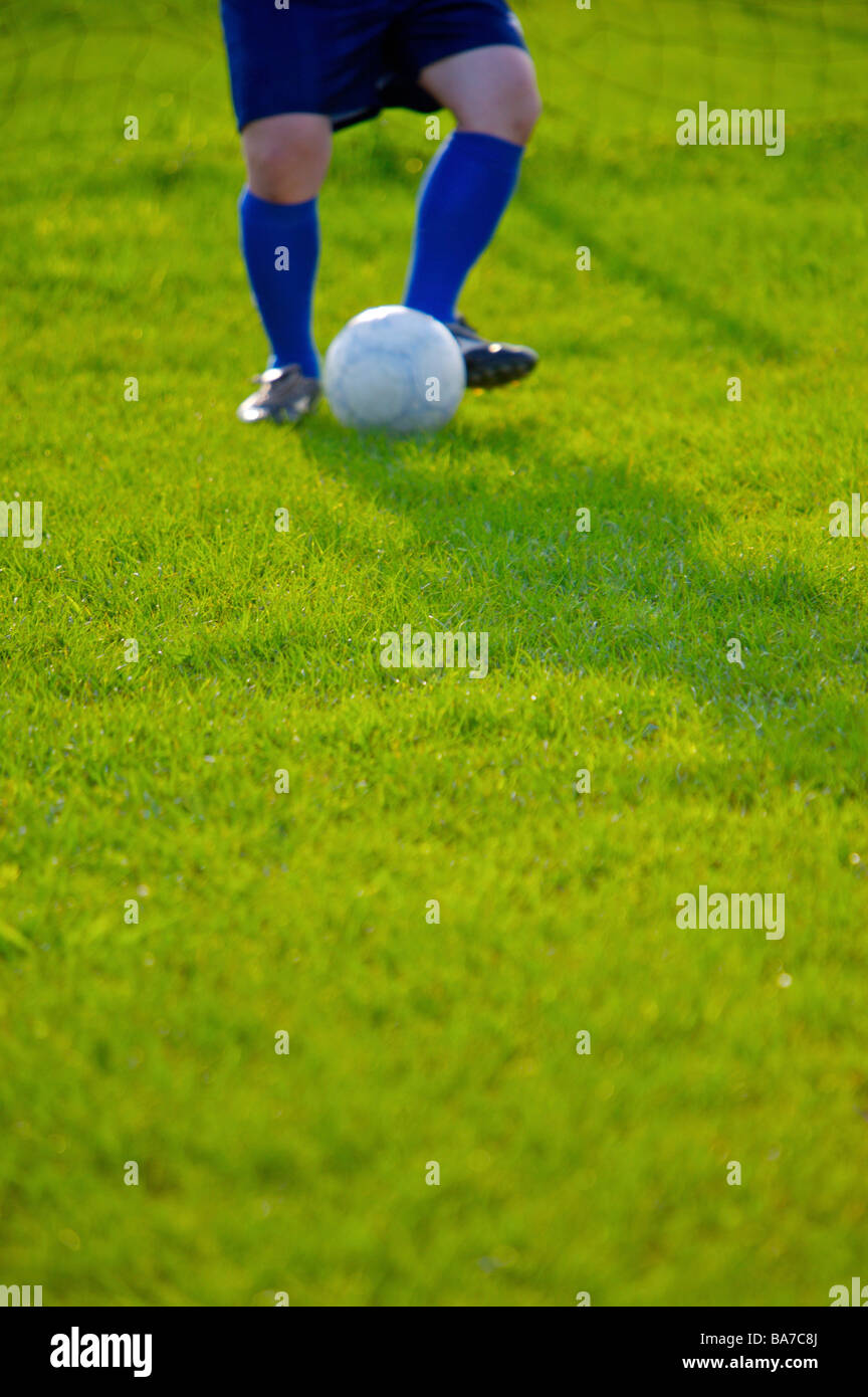 Giocatore di calcio calci palla metà sezione Foto Stock