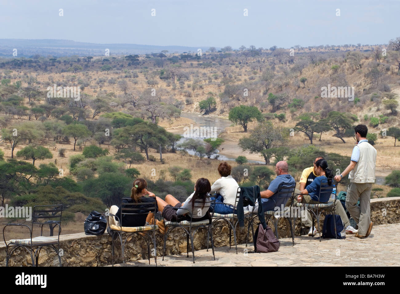 I visitatori a guardare la fauna selvatica dalla terrazza di un lodge nel Parco Nazionale di Tarangire e Tanzania Foto Stock