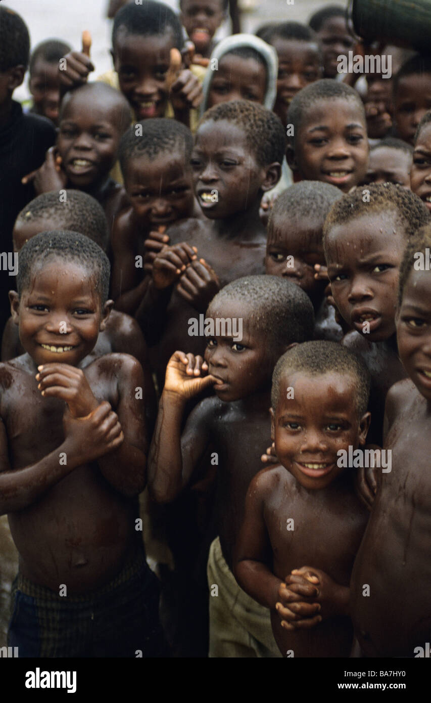 I bambini rifugiati il raffreddamento al di sotto di un serbatoio di acqua in sfollati camp Malawi Foto Stock