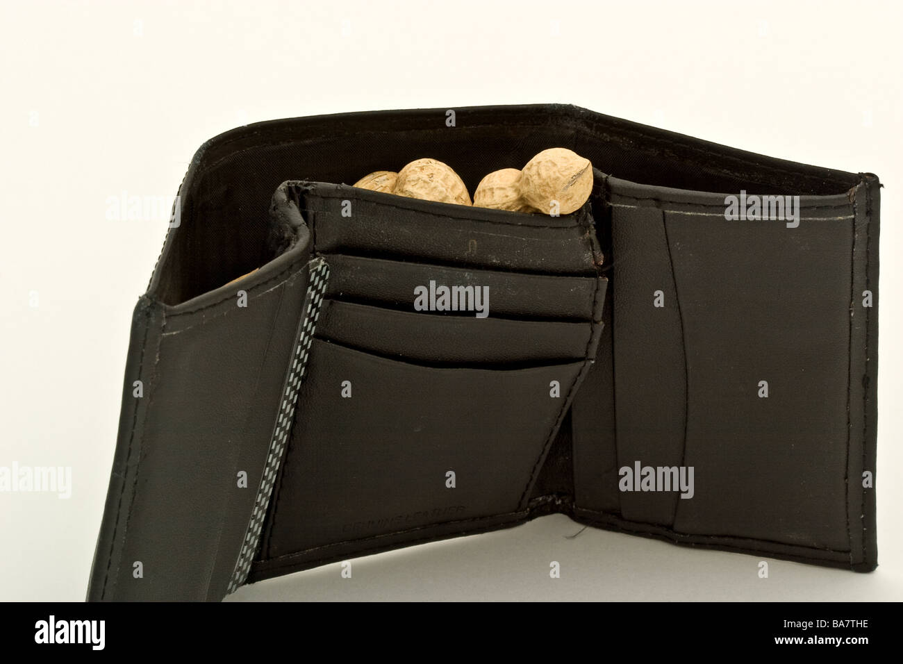 Un portafoglio in pelle pieno di arachidi Foto Stock