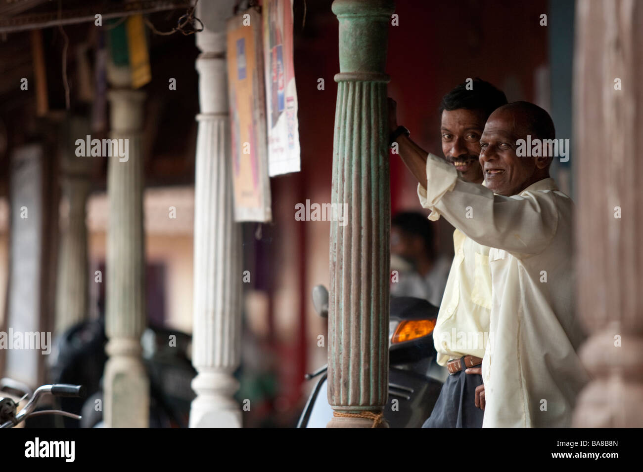 Un paio di locali da Siolim Goa India stand sotto il portico di alcuni negozi il Venerdì Santo. Foto Stock