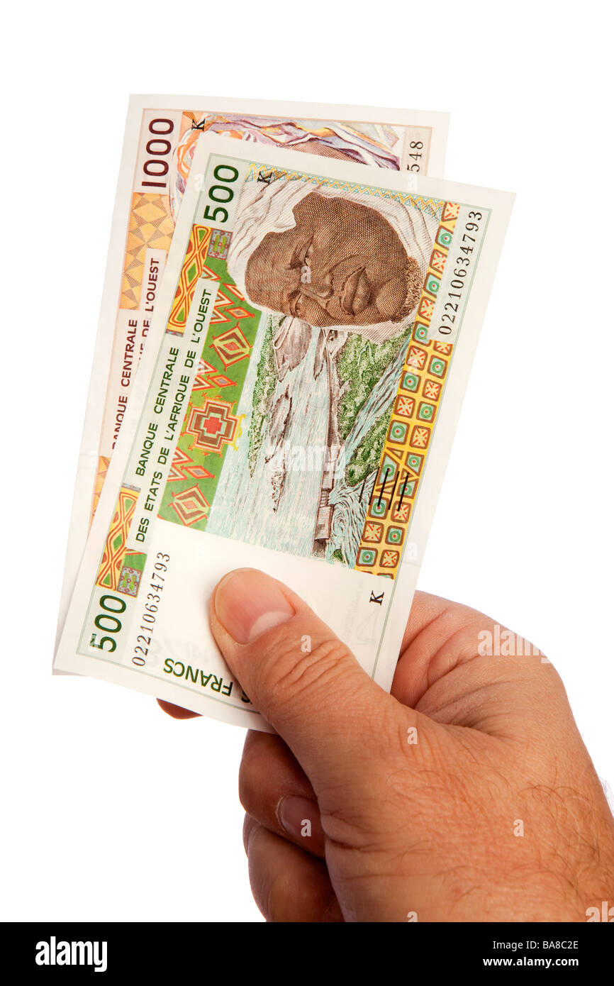 Maschio di denaro mano azienda manciata di senegalesi moneta CFA Foto Stock