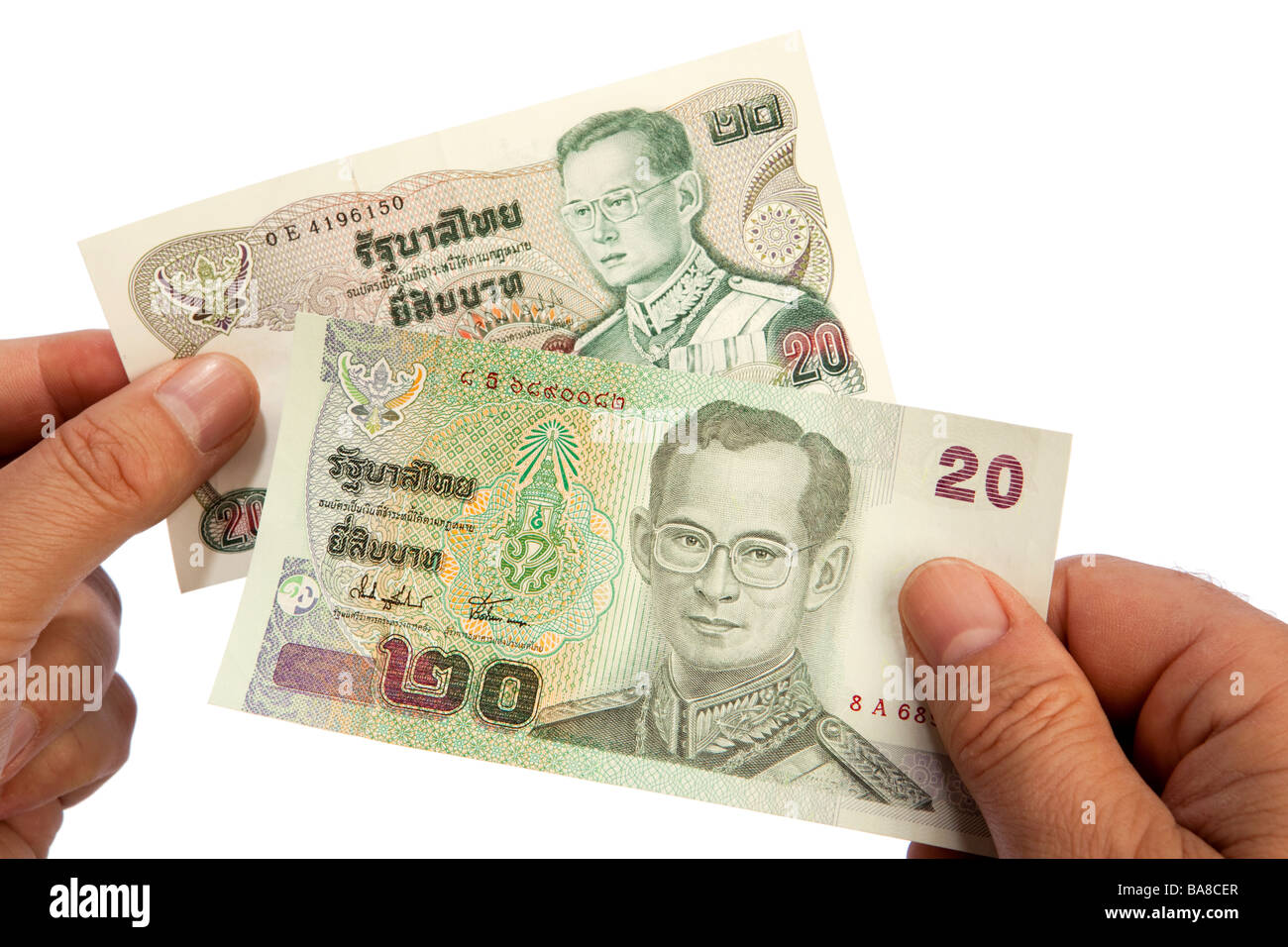 Maschio di denaro mani tenendo il vecchio e il nuovo 20 Thai baht valuta banconote Foto Stock