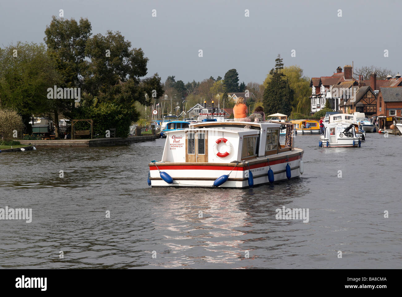 Il fiume Bure a Horning raggiungere il Parco Nazionale Broads del Norfolk, Inghilterra con una barca a motore e il lancio di una giornata di primavera. Foto Stock