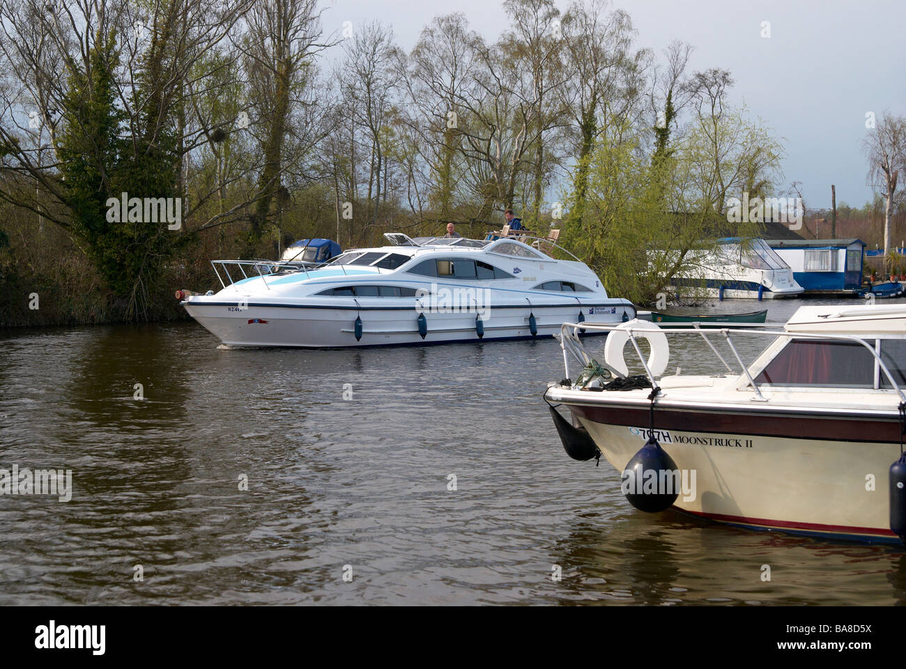 Il fiume Bure a Horning raggiungere il Parco Nazionale Broads del Norfolk, Inghilterra con una barca a motore e il lancio di una giornata di primavera. Foto Stock