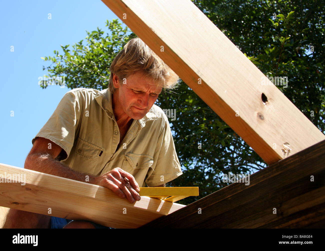 Un builder usa geometria di lavorare fuori angoli su un tetto a falde Foto Stock