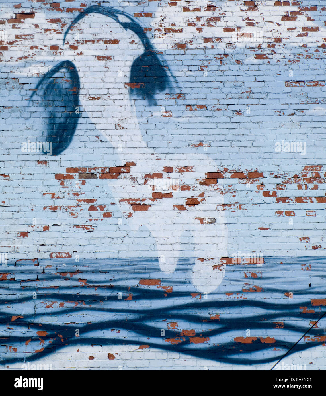 Graffiti di balena sul muro di mattoni con onde Foto Stock