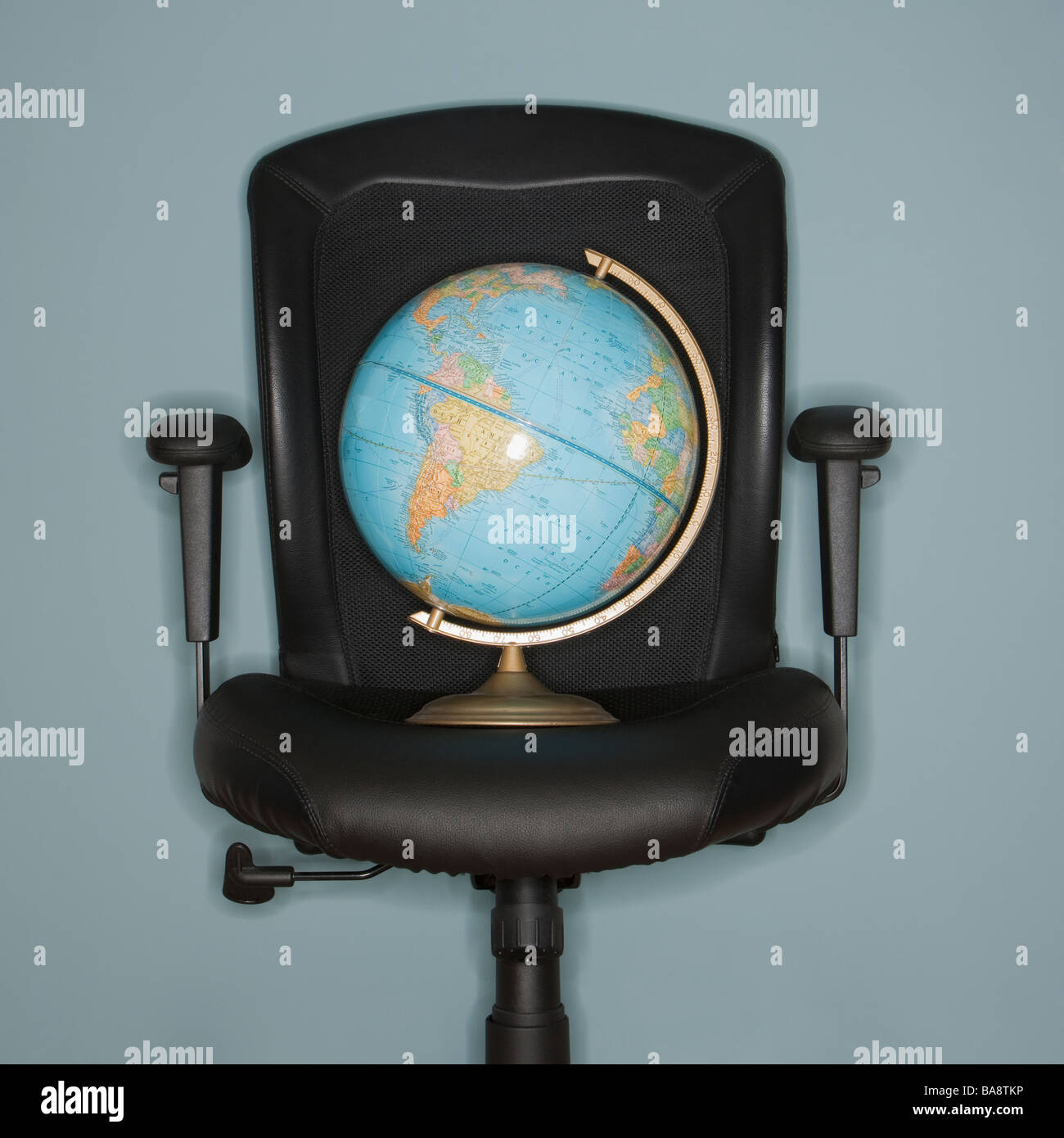 Globo sulla sedia da ufficio Foto Stock