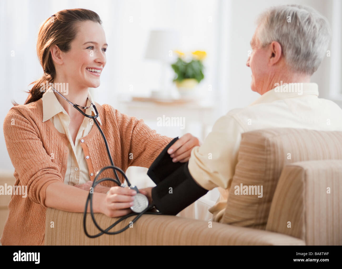 L'infermiera prendere senior dell'uomo della pressione del sangue Foto Stock