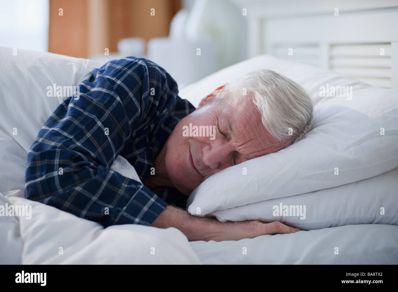 Senior uomo dorme nel letto Foto Stock