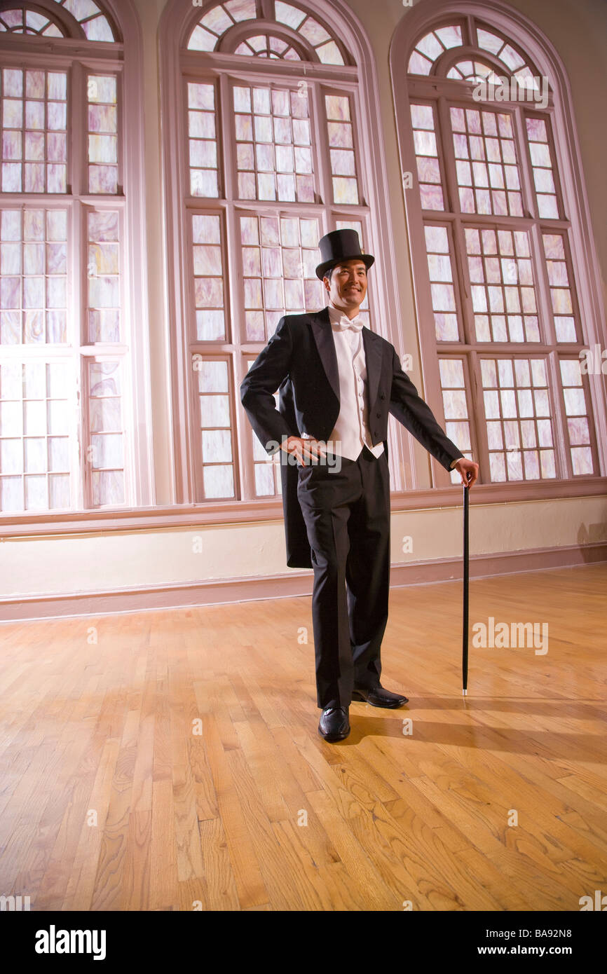 Uomo in smoking con top hat e della canna da zucchero in piedi nella sala da  ballo Foto stock - Alamy