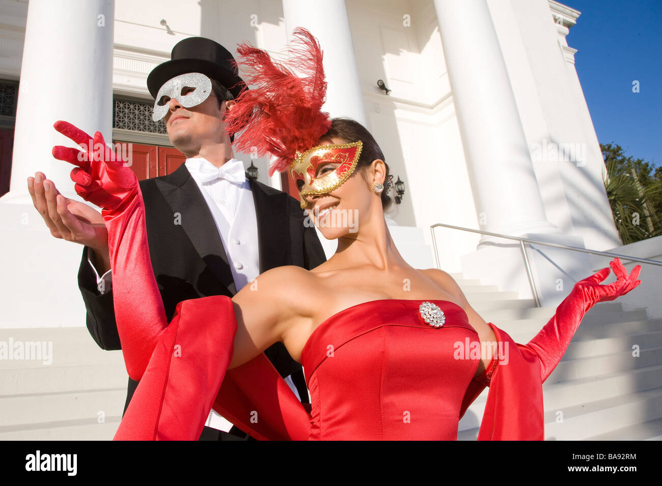Matura in costumi masquerade in piedi al di fuori del teatro Foto Stock
