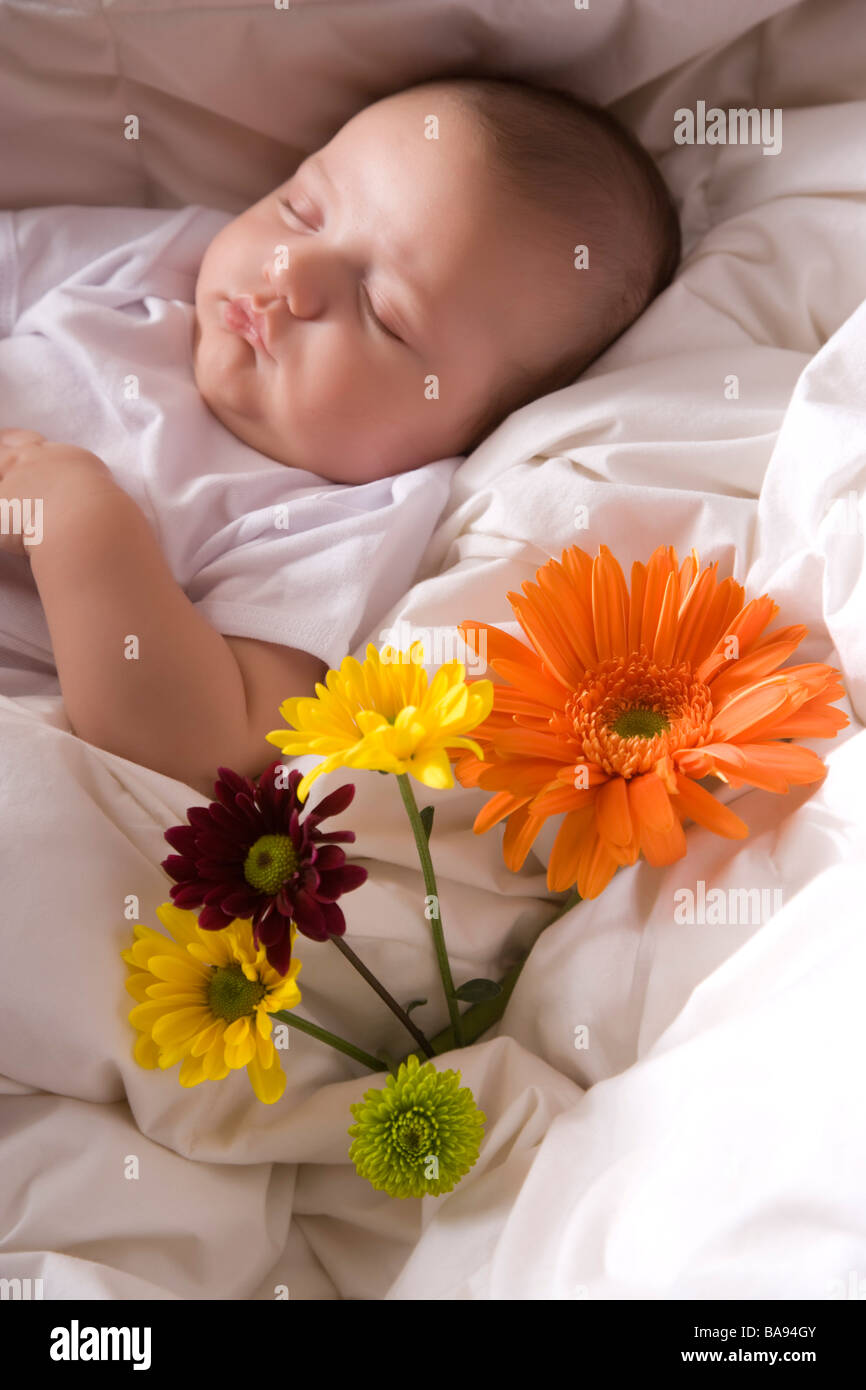3 mese fa il bambino addormentato nel letto con i fiori Foto Stock