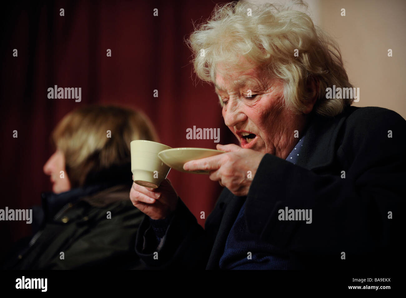 Una donna a cuor leggero bere il tè da piattino. Foto da Jim Holden. Foto Stock