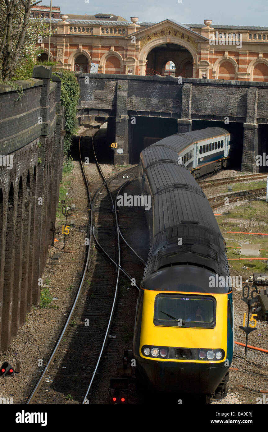 Treno emergente dal tunnel e serpeggiando lungo il binario ferroviario Foto Stock