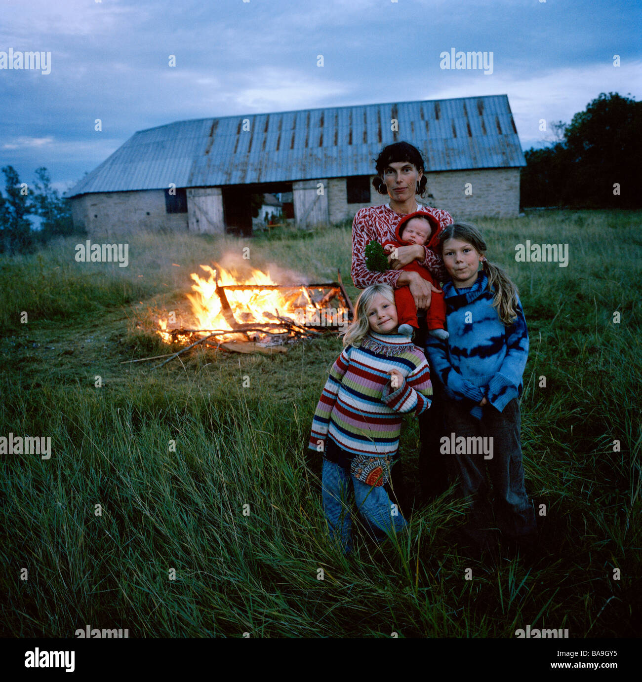 Madre e le sue figlie in piedi di fronte a un fuoco, Oland, Svezia. Foto Stock