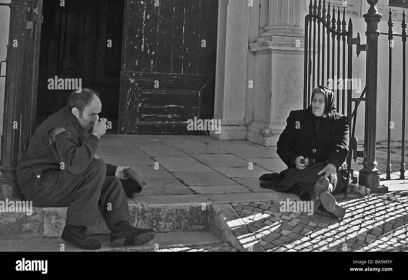 Due mendicanti all'esterno della chiesa Foto Stock