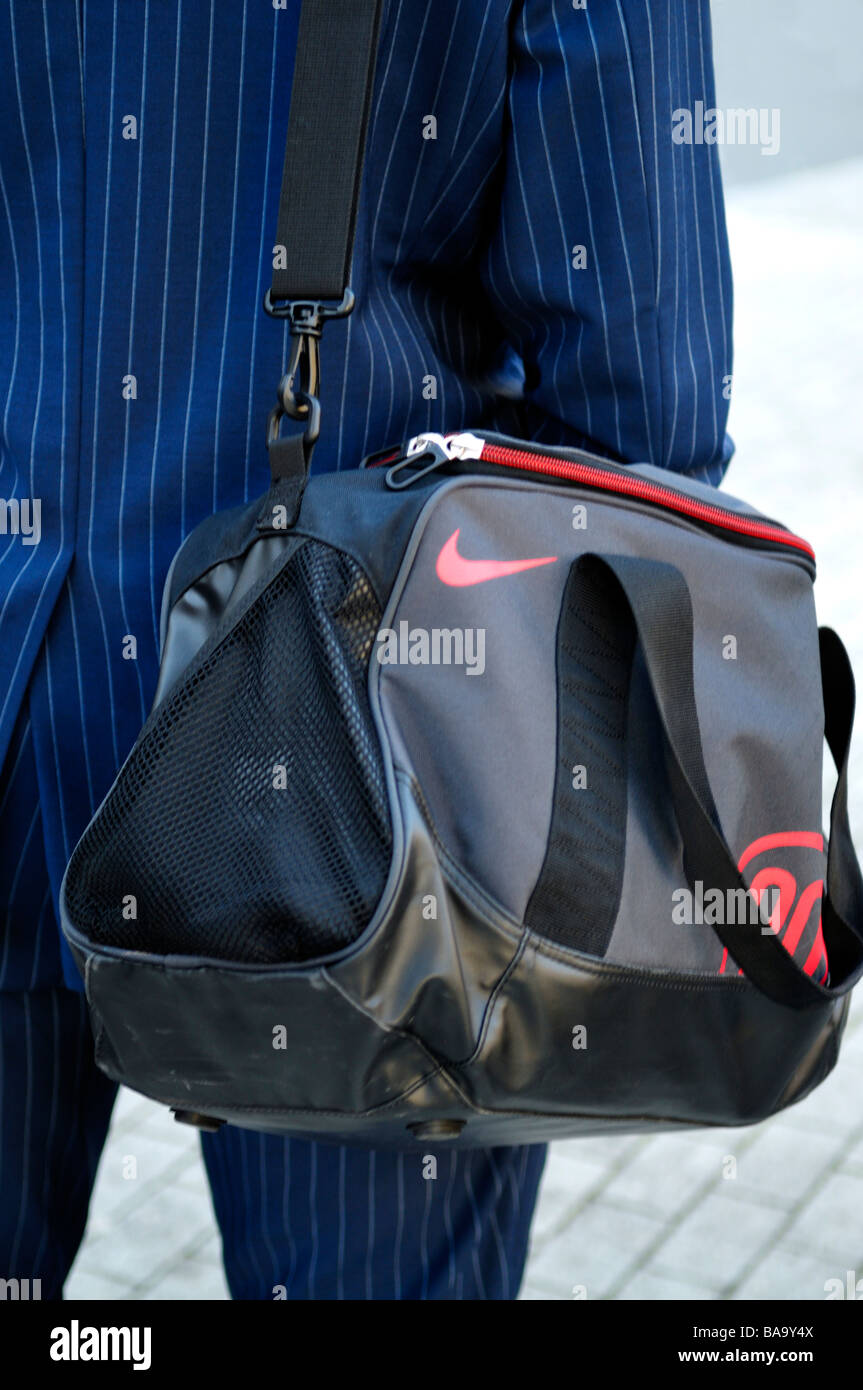 Imprenditore a piedi con borsa sportiva sulla spalla Foto Stock