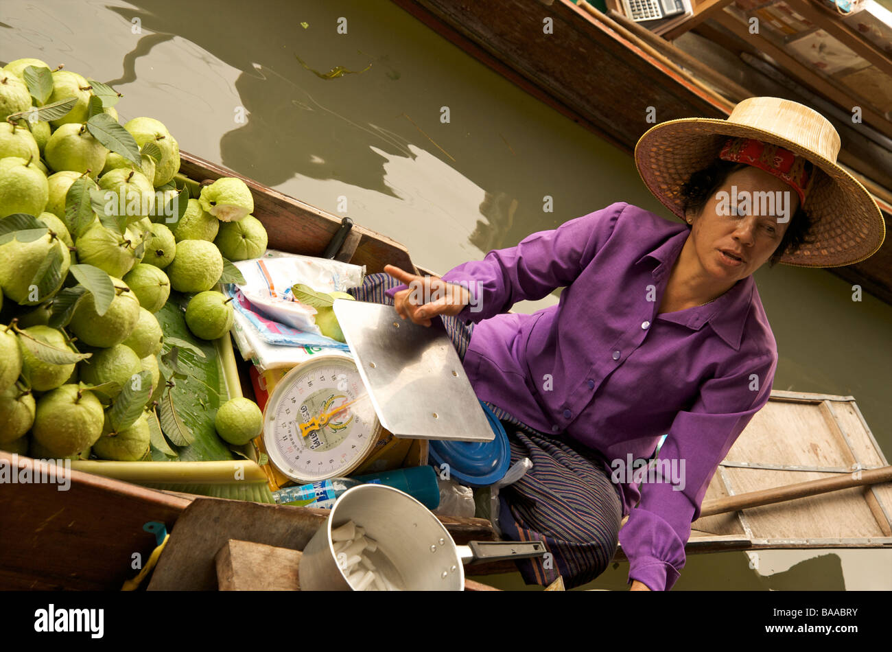 Una donna tailandese Thai vendita mele verdi da la sua barca al mercato galleggiante vicino a Bangkok in Tailandia Foto Stock