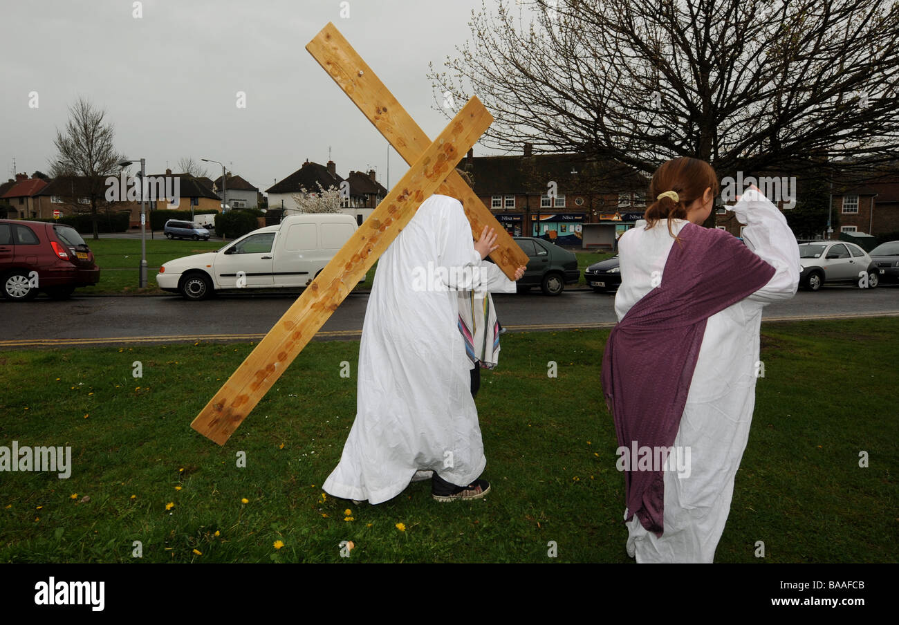Un adolescente porta una croce sulle spalle come egli gioca la parte di Gesù in una nuova promulgazione della Passione il servizio sul Venerdì Santo Foto Stock
